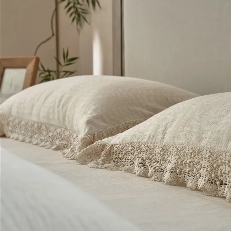 Close-up of two elegant lace pillowcases, showcasing intricate lace detailing on soft cotton linen fabric.